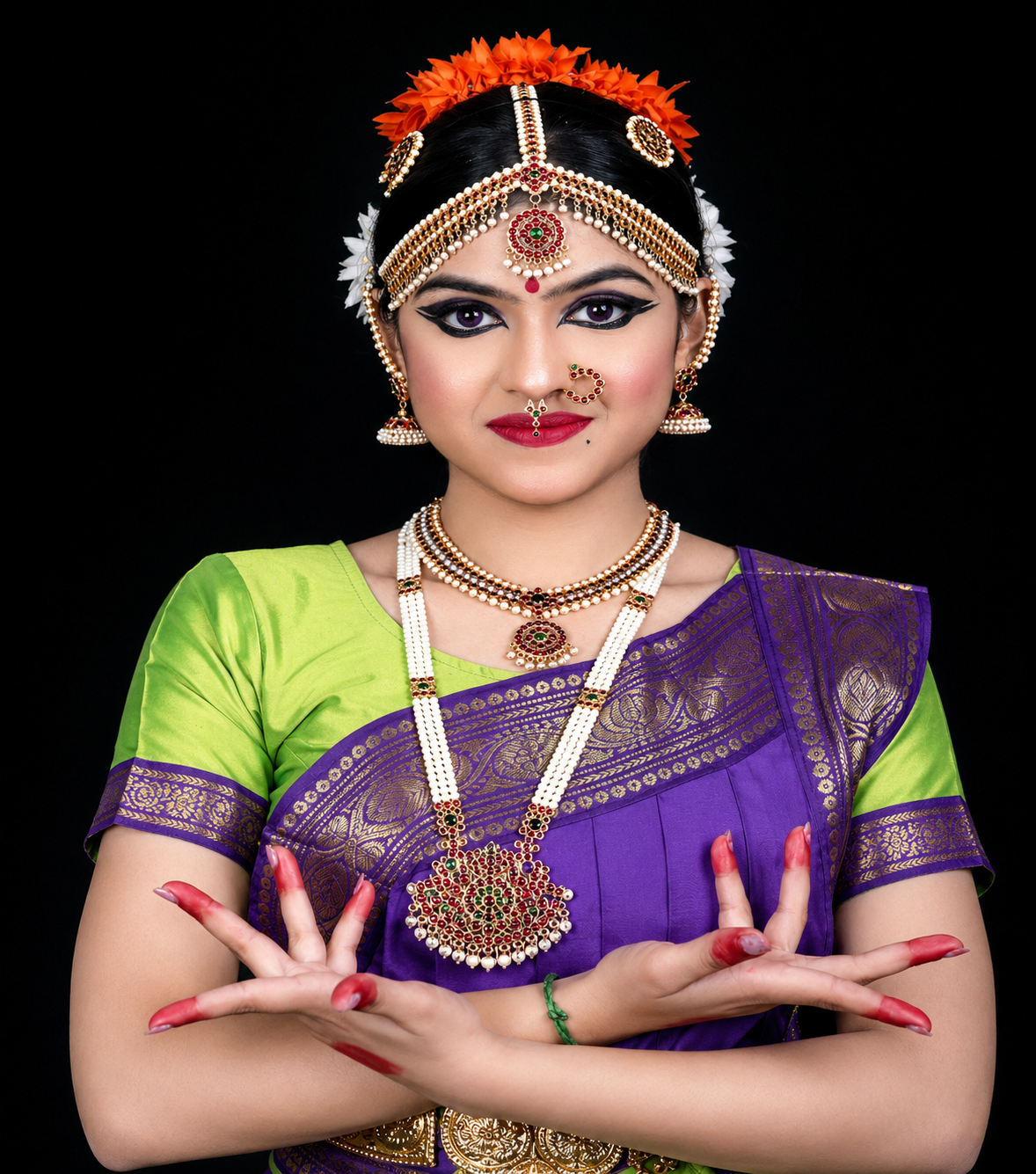Bharatanatyam dancer in blue costume seated in a performance pose